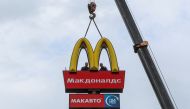 Workers use a crane to dismantle the McDonald's Golden Arches while removing the logo signage from a drive-through restaurant of McDonald's in the town of Kingisepp in the Leningrad region, Russia, June 8, 2022. (REUTERS/Anton Vaganov)