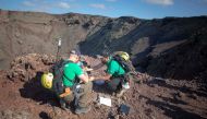 German astronaut Alexander Gerst (L) collects sample of an ancient volcano during a training program in Lanzarote to learn how to explore the Moon and Mars in the Timanfaya National Park on November 10, 2022. (Photo by DESIREE MARTIN / AFP)