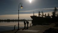 People speak with their smartphones on a bank of the Dnipro river after Russia's retreat from Kherson, in Kherson, Ukraine November 14, 2022. REUTERS/Valentyn Ogirenko