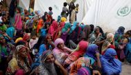 File photo: Women displaced because of the floods wait to receive food handouts while taking refuge in a camp, in Sehwan, Pakistan, September 30, 2022. (Reuters/Akhtar Soomro)