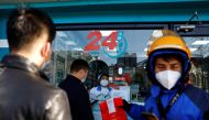 People line up to buy fever and cold medicine as a delivery worker picks up an order at a pharmacy, amid the coronavirus disease (COVID-19) outbreak, in Beijing, China December 6, 2022. Reuters/Tingshu Wang