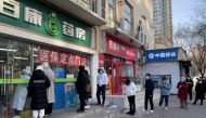 People wearing masks line up outside a pharmacy to buy products as coronavirus disease (COVID-19) outbreaks continue in Beijing, China December 6, 2022. REUTERS/Alessandro Diviggiano