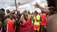 A group of participants and supporters dance during the Maasai Olympics in Kimana district, on December 10, 2022, a sports event first held in 2012, in the Amboseli-Tsavo ecosystem. (Photo by Fredrik Lerneryd / AFP)