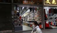 A person walks past shops, after the government eased curbs on the coronavirus disease (COVID-19) control, in Wuhan, Hubei province, China December 10, 2022. REUTERS/Martin Pollard