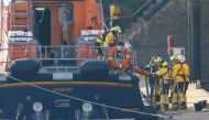 Rescue workers carry a body bag on a stretcher, as they return to the Port of Dover amid a rescue operation of a missing migrant boat, in Dover, Britain December 14, 2022. Reuters/Peter Nicholls