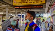 A health worker collects a swab sample for Covid-19 screening from a passenger arriving at Prayagraj junction on December 23, 2022. (Photo by Sanjay Kanojia / AFP)
