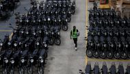 A worker walks next to assembled electric motorcycles at ARC Ride's warehouse in Industrial Area, Nairobi, Kenya November 2, 2022. REUTERS/Monicah Mwangi
 