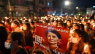 In this file photo taken on March 13, 2021, a protester holds a poster with an image of detained civilian leader Aung San Suu Kyi during a candlelight vigil to honour those who have died during demonstrations against the military coup in Yangon. (AFP)