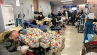 Patients on stretchers are seen at Tongren hospital in Shanghai on January 3, 2023. - A senior doctor at Shanghai's Ruijin Hospital has said 70 percent of the megacity's population may have been infected with Covid-19 during China's huge surge in cases, state media reported on January 3. (Photo by Hector RETAMAL / AFP)