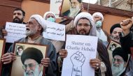 Demonstrators gather with images of Iran's supreme leader Ayatollah Ali Khamenei during a protest against defamatory cartoons depicting him published by French satirical weekly Charlie Hebdo, outside the French embassy in Iran's capital Tehran on January 8, 2023. (Photo by ATTA KENARE / AFP)