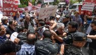 Tunisian demonstrators blocked by police during a rally against their president, in the capital Tunis, on June 4, 2022. (AFP)
