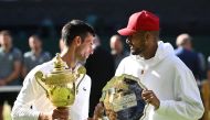 Serbia's Novak Djokovic poses with the trophy after winning the Wimbledon men's singles final alongside runner up Australia's Nick Kyrgios, July 2022. REUTERS/Toby Melville/File Photo
