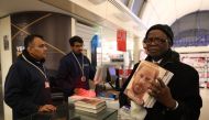 A man holds three copies of the book Spare', by Britain's Prince Harry, Duke of Sussex during a special midnight opening event for the release of the memoire, at the WHSmith bookstore, at Victoria Station in London, on January 9, 2023. (Photo by ISABEL INFANTES / AFP)