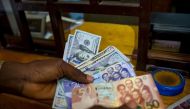 A man trades US dollars for Ghanaian cedis at a currency exchange office in Accra, Ghana, June 15, 2015. Picture taken June 15. File Photo / Reuters
