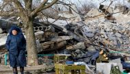 An elderly woman walks near debris of a destroyed building purported to be a vocational college used as temporary accommodation for Russian soldiers, dozens of whom were killed in a Ukrainian missile strike as stated previously by Russia's Defence Ministry, in the course of Russia-Ukraine conflict in Makiivka (Makeyevka), Russian-controlled Ukraine, January 10, 2023. REUTERS/Alexander Ermochenko TPX