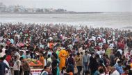 A man dressed as a teddy bear entertains people at a crowded beach in Mumbai, India, June 12, 2022. (REUTERS/Francis Mascarenhas)