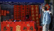 A calligrapher writes spring couplets, a kind of Lunar New Year decorations, at a stall along a street in Foshan, in southern China's Guangdong province on January 18, ahead of the start of the Lunar New Year, which ushers in the Year of the Rabbit on January 22. (Photo by Jade Gao / AFP)