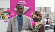 Qatar National Library executive director, Tan Huism (right) receives a donation of a book from the author, Fidelis Iyebote.