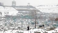 An Afghan man walks on a snow-covered cemetery in Kabul, Afghanistan, January 11, 2023. REUTERS/Ali Khara/File Photo







