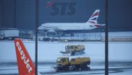 Snow ploughs clear snow from the airfield after overnight snow forced the closure of Manchester airport, in Manchester, Britain, on January 19, 2023. REUTERS/Phil Noble
