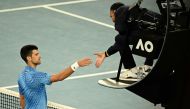 Serbia's Novak Djokovic shakes hands with the umpire after the men's singles match against Australia's Alex De Minaur on day eight of the Australian Open tennis tournament in Melbourne on January 23, 2023. (Photo by ANTHONY WALLACE / AFP)
