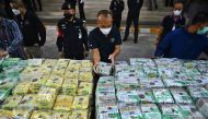 Thai policemen display packages of crystal methamphetamine before a press conference at the Narcotics Suppression Bureau in Bangkok on January 24, 2023. (Photo by Lillian Suwanrumpha / AFP)