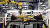 Workers fit a roof panel on the TX electric taxi production line inside the LEVC (London Electric Vehicle Company) factory in Coventry, Britain, January 18, 2023. File Photo: Reuters/Phil Noble





