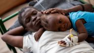 Karina Joseph, 19, comforts her 2-year-old child Holanda Sineus as she receives treatment for cholera in a tent at a Doctors Without Borders hospital in Cite Soleil, a densely populated commune of Port-au-Prince, Haiti October 15, 2022. File Photo: REUTERS/Ricardo Arduengo/File Photo