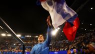 Serbia’s Novak Djokovic signs autographs for fans after winning his semi final match against Tommy Paul of the US at the Australian Open in Melbourne on January 27, 2023. (REUTERS/Hannah Mckay)