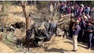 People gather around the debris of a crashed aircraft in Bharatpur, Rajasthan, India, January 28, 2023 in this screen grab obtained from a handout video. ANI/Handout via Reuters