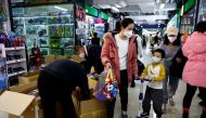 A woman and a child walk past workers sorting toys at a shopping mall in Beijing, China on January 11, 2023. File Photo / Reuters