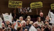Protesters hold placards reading (LtoR) 