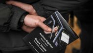 A volunteer holds a booklet with a portrait of Andrew Bagshaw, one of the two British volunteers killed in eastern Ukraine while attempting a rescue from Soledar, amid Russia's attack on Ukraine, during a memorial service in Kyiv, Ukraine, January 29, 2023. (REUTERS/Gleb Garanich)
