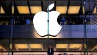 A customer stands underneath an illuminated Apple logo as he looks out the window of the Apple store located in central Sydney, Australia, on May 28, 2018. File Photo / Reuters