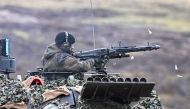 A tank crew member fires a tank mounted machine gun as German Defense minister Boris Pistorius visits Leopard II tanks that are due to be supplied to Ukraine at the tank brigade Lipperland of Germany's army and part of the Bundeswehr, in Augustdorf, Germany, February 1, 2023. (REUTERS/Benjamin Westhoff)
