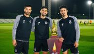 FROM LEFT: Al Sadd's Boualem Khoukhi, Tarek Salman and Baghdad Bounedjah pose with the Qatar Cup trophy. 