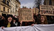 A protester (centre) holds a placard reading 