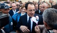 Former Cypriot foreign minister and presidential candidate Nikos Christodoulides is flanked by supporters as he arrives to cast his vote at the Geroskypou polling centre in the western Paphos district, on February 12, 2023. (Photo by Iakovos Hatzistavrou / AFP)