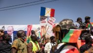 A demonstrator holds placards during a protest to support Burkina Faso President Captain Ibrahim Traore and to demand the departure of France's ambassador and military forces, in Ouagadougou, on January 20, 2023. (Photo by OLYMPIA DE MAISMONT / AFP)