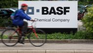 A cyclist rides his bike past the entrance of the BASF plant and former Ciba production site in Schweizerhalle near Basel, Switzerland July 7, 2009. REUTERS/Christian Hartmann
