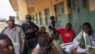 People watch as ballot papers are counted at a polling station in Abuja on February 25, 2023, during Nigeria's presidential and general election. (Photo by Michele Spatari / AFP)
 
