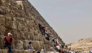 Tourists visit the Great Pyramid of Khufu (Cheops) at the Giza Pyramids necropolis on the southwestern outskirts of Cairo, on March 2, 2023. - A hidden corridor of 9 metre-long has been spotted close to the main entrance of the pyramid, a discovery made under the Scan Pyramids project that has been in place since 2015, Egyptian antiquities officials announced on March 2. (Photo by Khaled DESOUKI / AFP) 