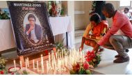 Mourners place candles in a room of Radio Amplitude FM where a portrait of journalist Martinez Zogo has been placed to pay tribute to him, in the Elig Essono district in Yaounde on January 23, 2023. File photo / AFP