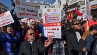 Demonstrators lift placards during an antigovernmental demonstration called for by the powerful trades union federation UGTT in Tunis, on March 4, 2023. (Photo by FETHI BELAID / AFP)