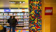 This file photo taken on November 29, 2022 shows people checking LEGO boxes at a shop in the hotel LEGOLAND in Billund, Denmark. - Lego, the world's number one toymaker, said on March 7, 2023 that its revenue and profits rose in 2022 as demand for its plastic bricks remained strong despite inflationary headwinds.  (Photo by Jonathan NACKSTRAND / AFP)