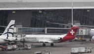 Baggage carts make their way past a Helvetic Airways aircraft from which about $50 million worth of diamonds were stolen on the tarmac of Brussels international airport, on Feb. 19, 2013.