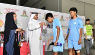 Chief Administrative Officer of QIC Group Rashid Al Buainain presents the medal to a student.