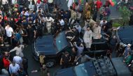Security personnel and supporters escort a vehicle carrying Pakistan's former prime minister Imran Khan during an election campaign rally for Punjab's provincial assembly to be held next month, in Lahore on March 13, 2023.  (Photo by Arif ALI / AFP)