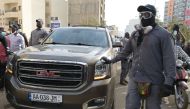 Members of the security team of Senegalese opposition leader Ousmane Sonko surrounds the vehicle he is travelling in to go to a court appearance in Dakar on March 16, 2023.  (Photo by SEYLLOU / AFP)