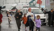 A family leaves a camp for those displaced after the February 6 earthquake, during heavy rains in Diyarbakir, on March 15, 2023. (Photo by ILYAS AKENGIN / AFP)